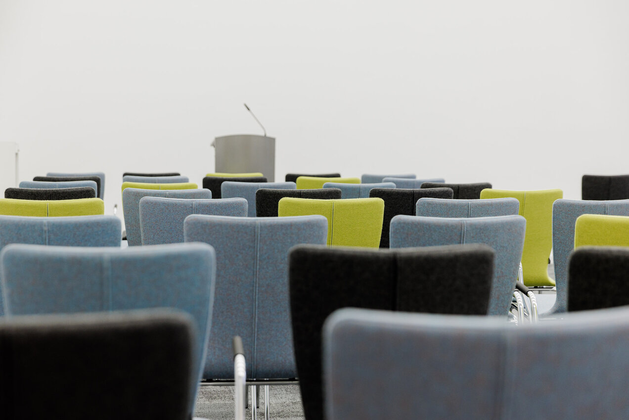 symbolic picture with chairs and a speaker's desk
