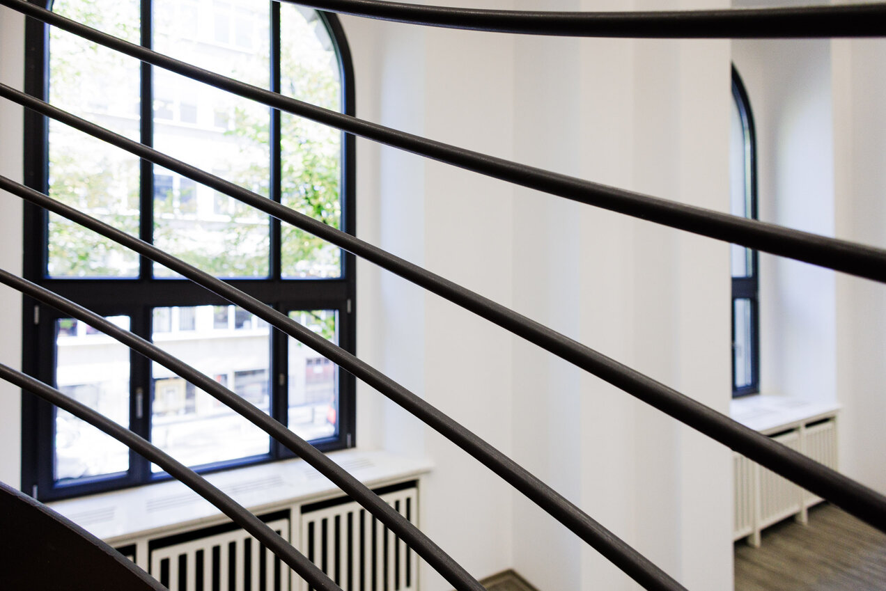 details of stair railings, a window arc in the background