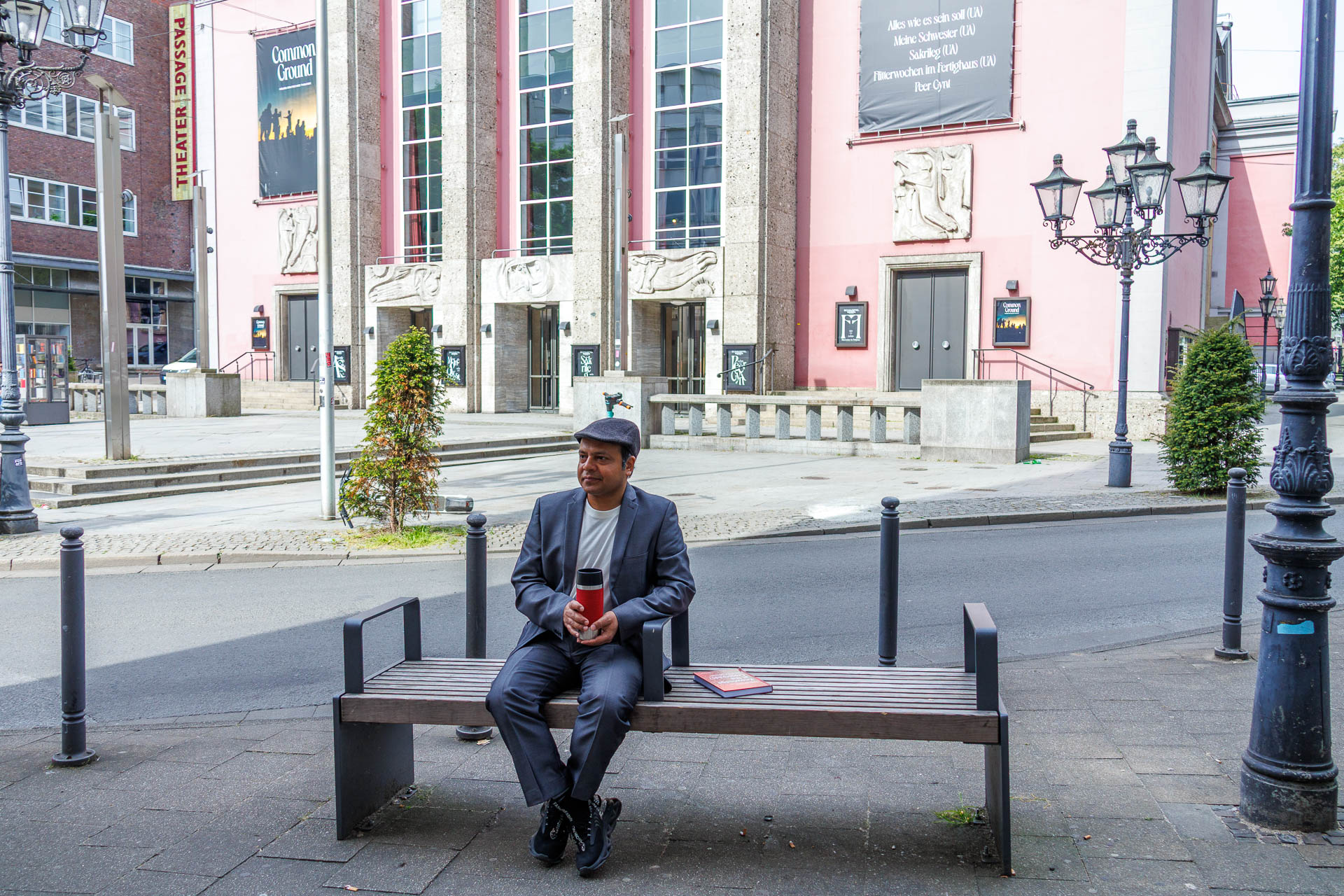 Imran Sabir sitting on a bench holding a thermos cup
