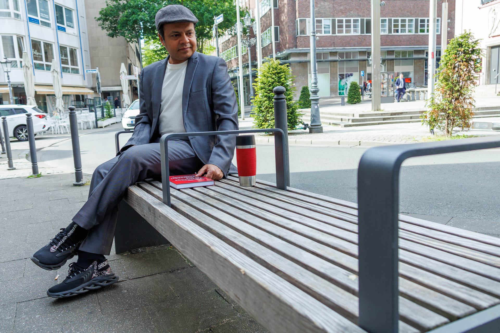 Imran Sabir sitting on bench with two metal armrests that make it impossible to lie down on it