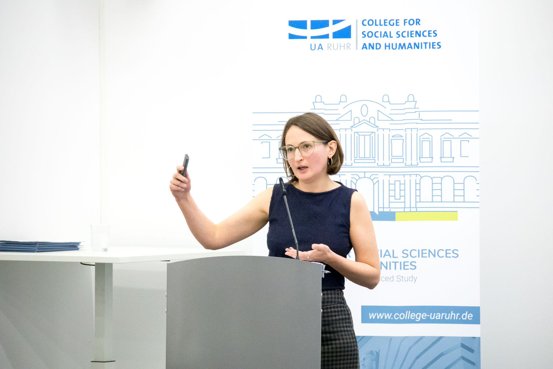 photo from the workshop 'Perpetrator Memory in Spanish culture', participants sitting at a table, a speaker presenting