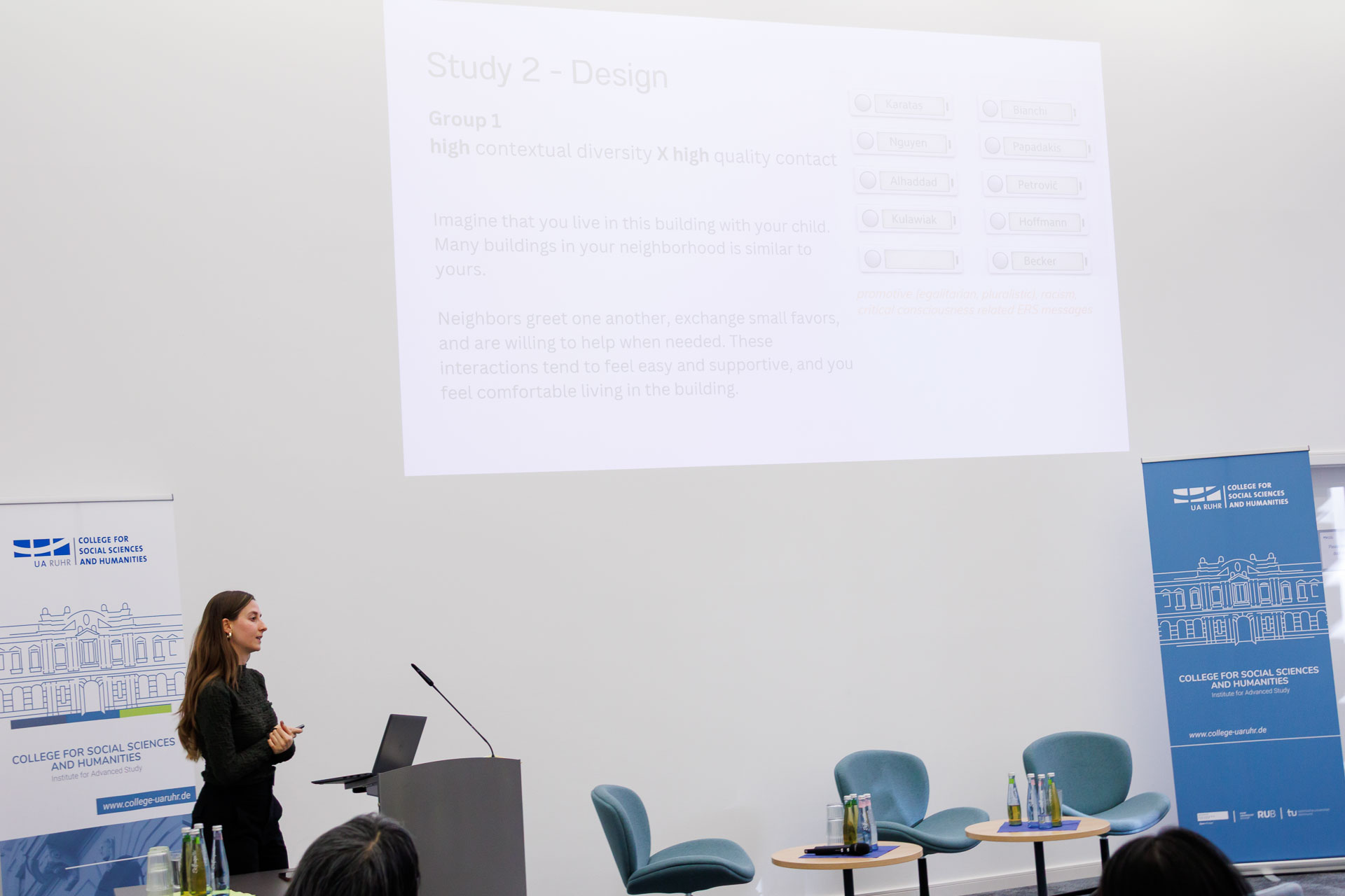 photo from the workshop 'Ethnic-Racial Socialisation', a speaker standing at a speaker's desk, a presentation slide in the background