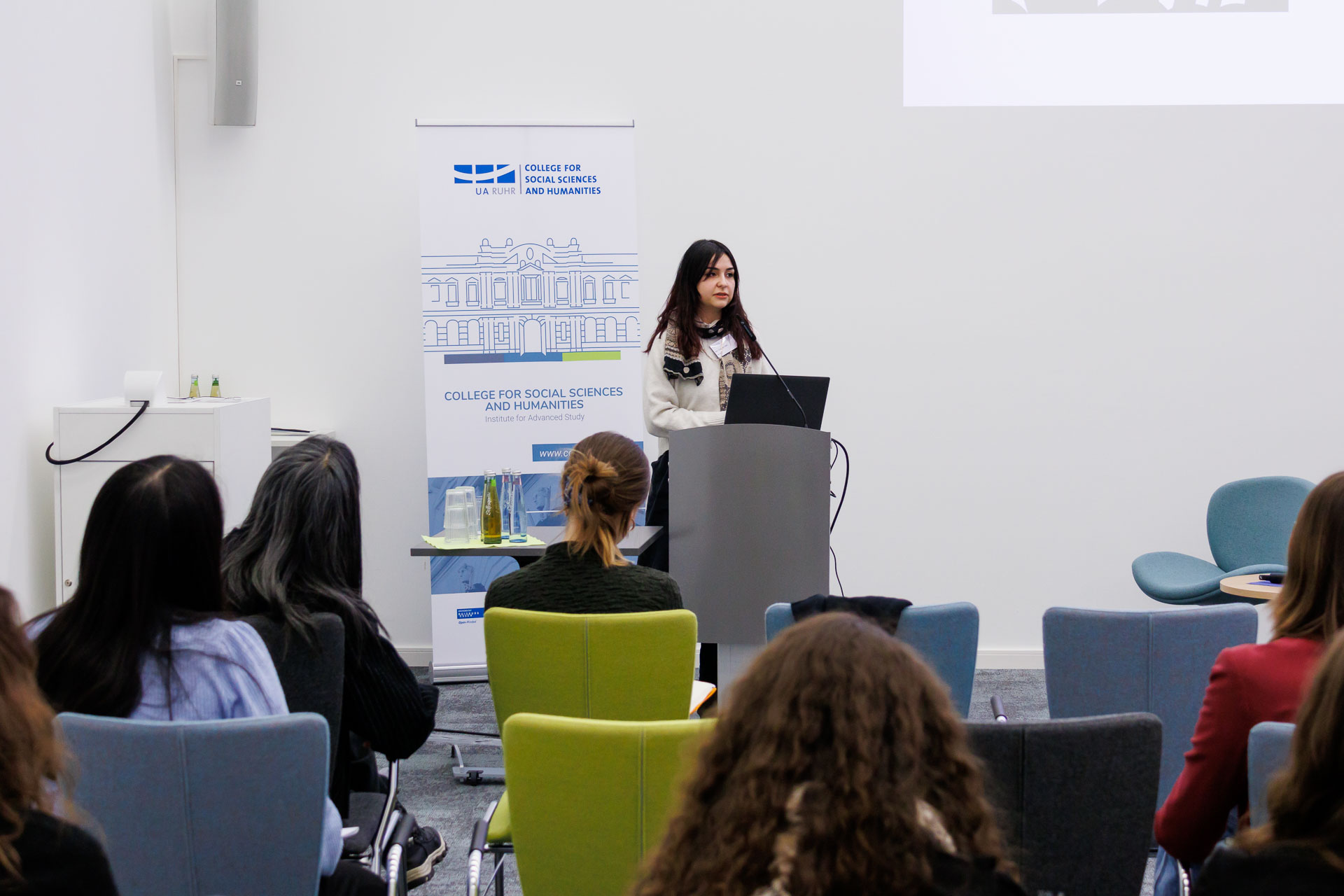 photo from the workshop 'Ethnic-Racial Socialisation', a speaker standing at a speaker's desk in front of the audience