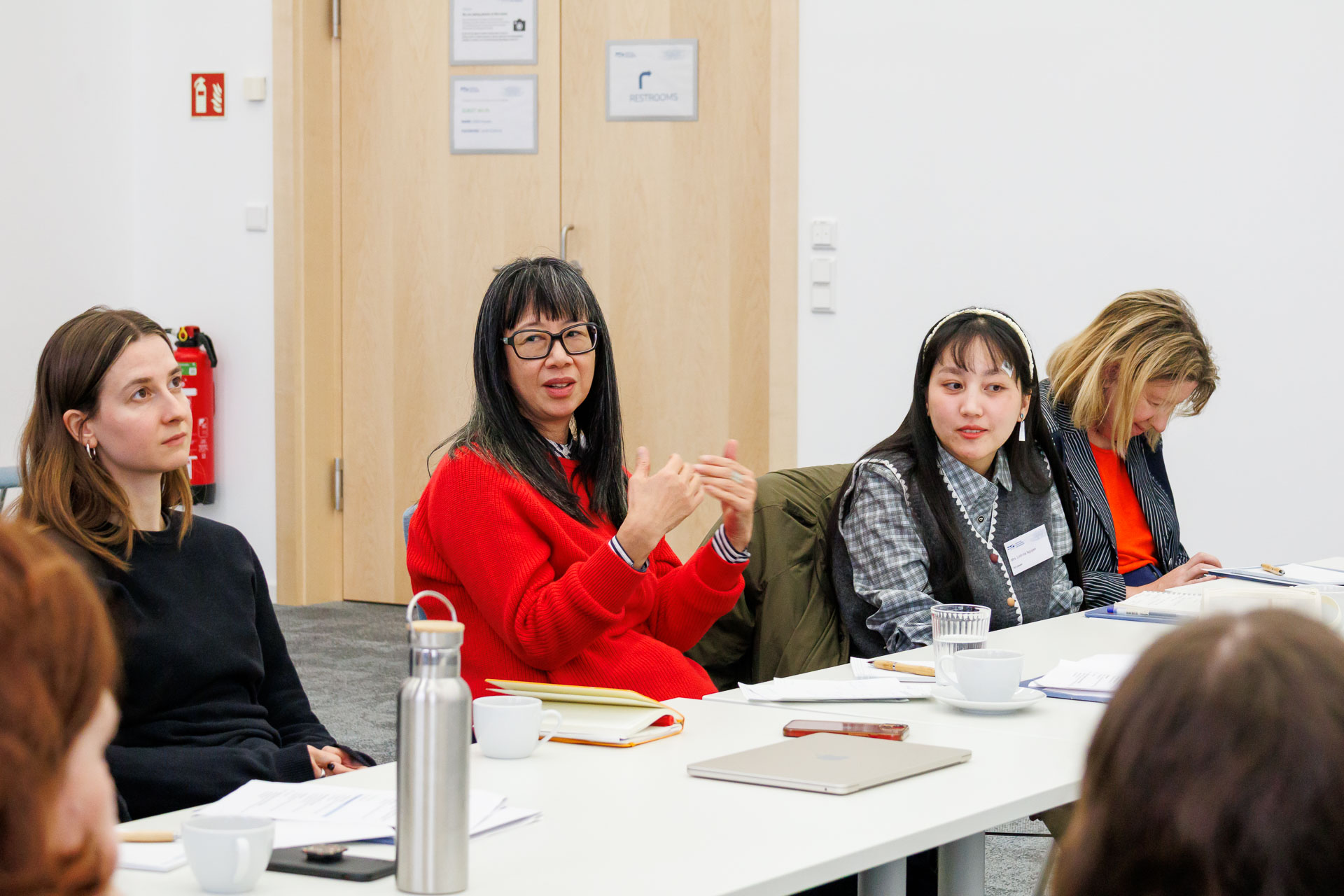 photo from the workshop 'Ethnic-Racial Socialisation', participants talking to each other at a large table
